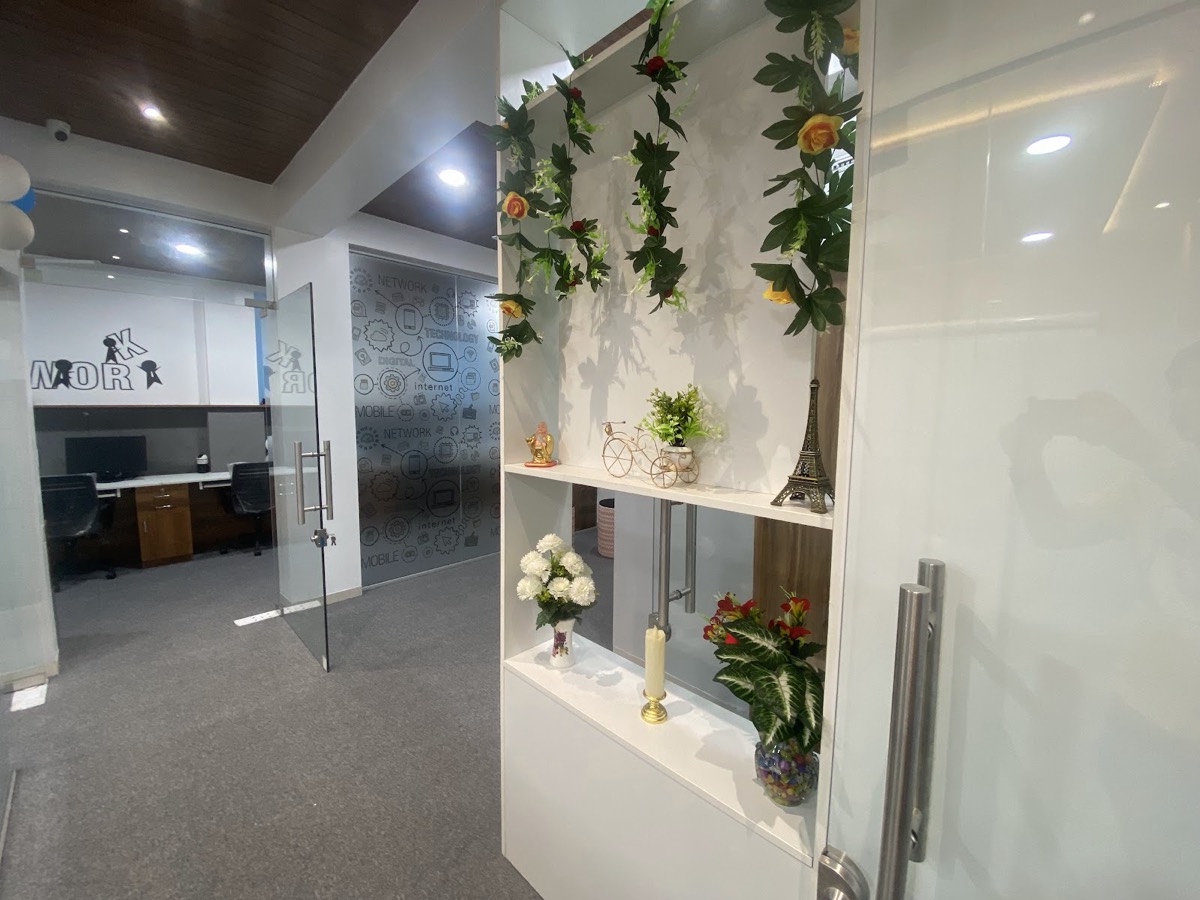 Office entrance with glass doors and shelves of plants